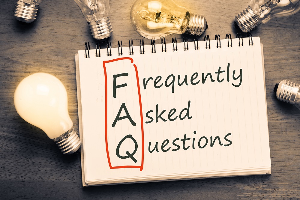 FAQ ( frequently asked questions ) text on notebook with many light bulbs